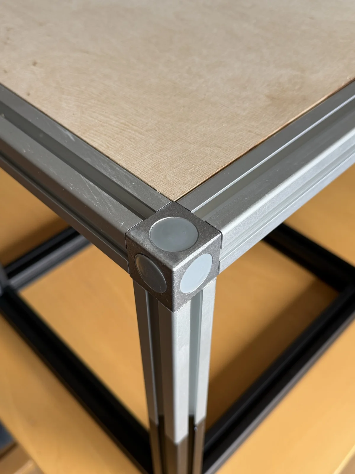 Foto: Regalhalter (S-Serie) tragen eine Holzplatte am fertig aufgebauten 30×30-Aluminiumrahmen
